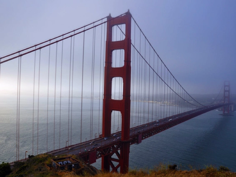 Golden Gate Bridge at sunrise with fog rolling over San Francisco Bay