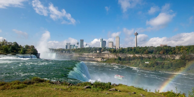 Niagara Falls at sunset with colorful skies and rushing water on the U.S. side