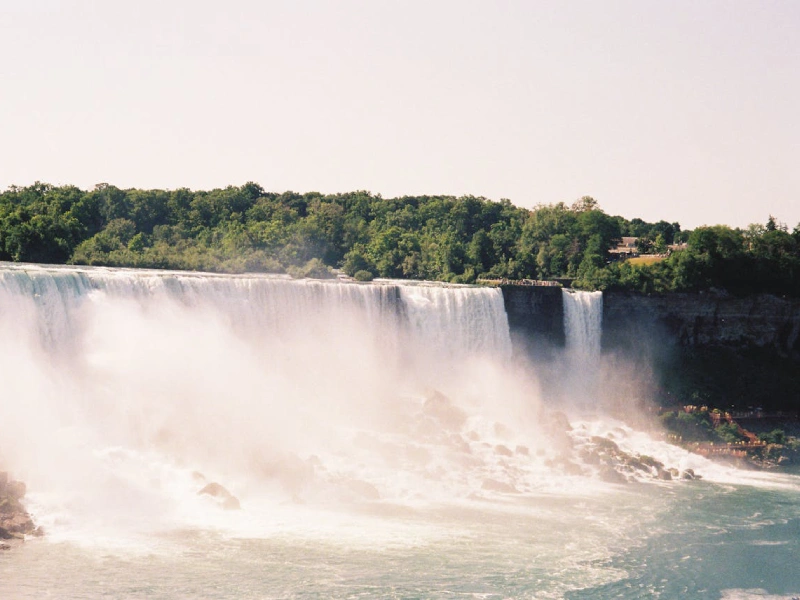 Panoramic view of Niagara Falls New York with cascading waterfalls and mist rising