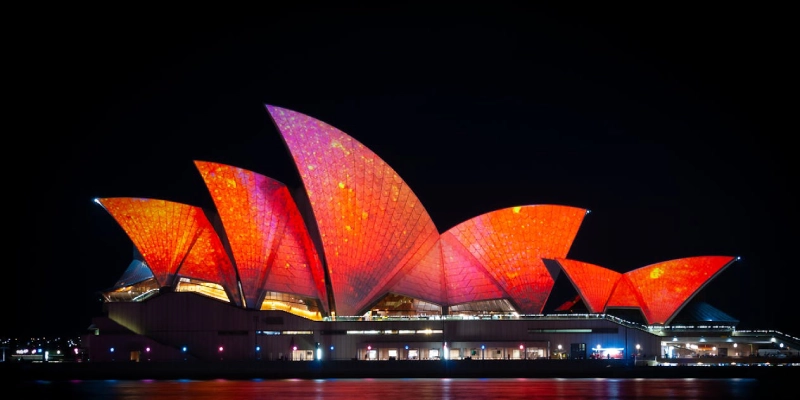 Sydney Opera House illuminated at night with golden lights