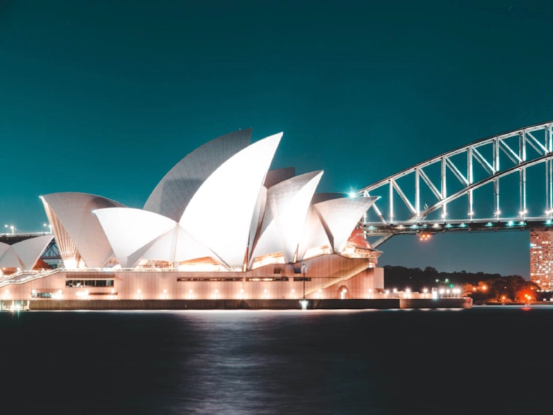 Sydney Opera House bathed in golden sunrise hues overlooking the waterfront