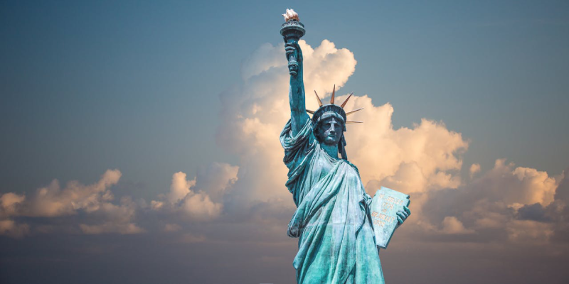Tourists taking photos near the base of the Statue of Liberty monument