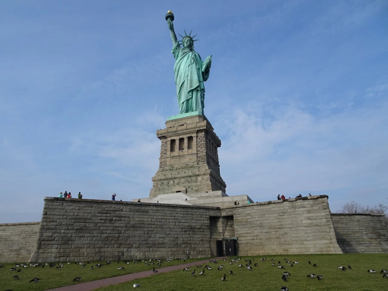 Statue of Liberty with blue sky backdrop viewed from Liberty Island in New York
